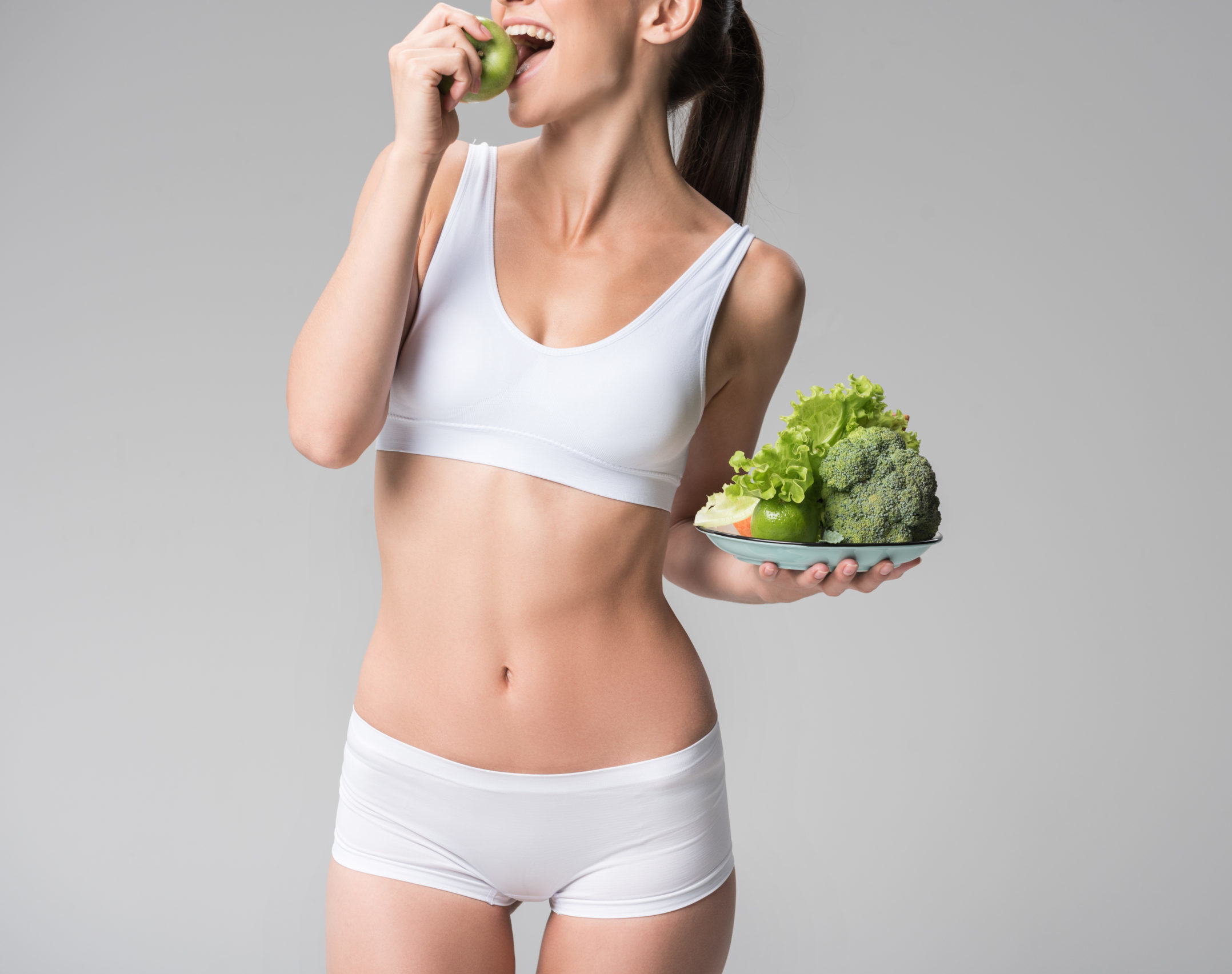 Happy young thin woman biting green fruit | Absolute Health Care | Newnan GA